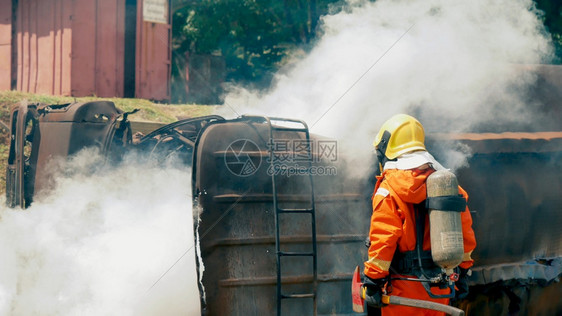 工作面具消防员用水管化学泡沫喷洒剂发动机与火焰战斗的消防员Fierman戴硬帽身穿防火灭器方面的营救训练制服斗争图片