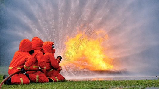 帽子紧急情况消防员用水管化学泡沫喷洒剂发动机与火焰战斗的消防员Fierman戴硬帽身穿防火灭器方面的营救训练制服危险的图片