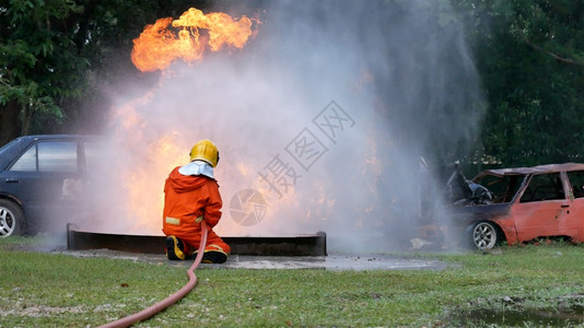 火车消防员用水管化学泡沫喷洒剂发动机与火焰战斗的消防员Fierman戴硬帽身穿防火灭器方面的营救训练制服火花安全的图片
