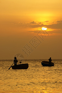 垂直的洋上美丽风景有两名渔民站立和在日落时圆船上划太阳下山日落时天空光亮黄亚洲人珊瑚礁图片