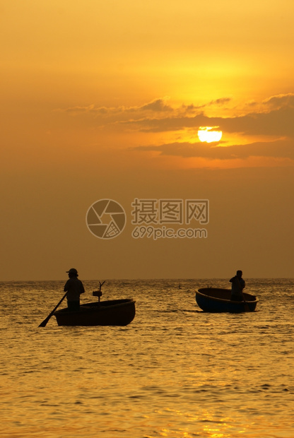 垂直的洋上美丽风景有两名渔民站立和在日落时圆船上划太阳下山日落时天空光亮黄亚洲人珊瑚礁图片