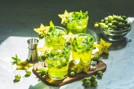 辛辣的印度人一种绿色鹅莓和卡兰波拉鸡尾酒配有石液冰和新鲜薄荷放在浅灰色混凝土桌上以刷新夏季饮料阳光明或脱毒饮料为例图片