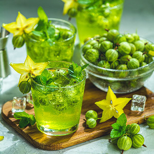 绿色鹅莓和卡兰波拉鸡尾酒配有石液冰和新鲜薄荷放在浅灰色混凝土桌上以刷新夏季饮料阳光明或脱毒饮料为例喝或者家图片