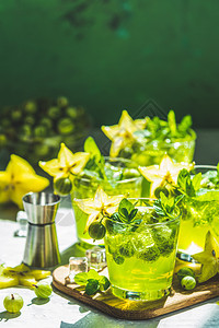 印度人药物或者绿色鹅莓和卡兰波拉鸡尾酒配有石液冰和新鲜薄荷放在浅灰色混凝土桌上以刷新夏季饮料阳光明或脱毒饮料为例图片
