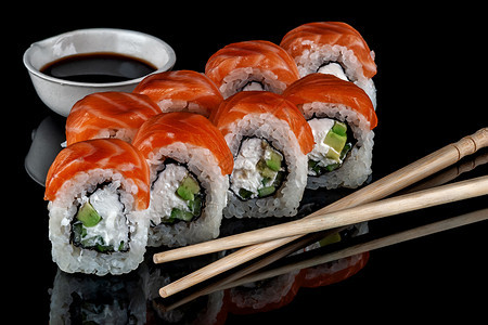 费城寿司卷加上筷子和酱油黑色背景反射饭团碗生鱼片图片
