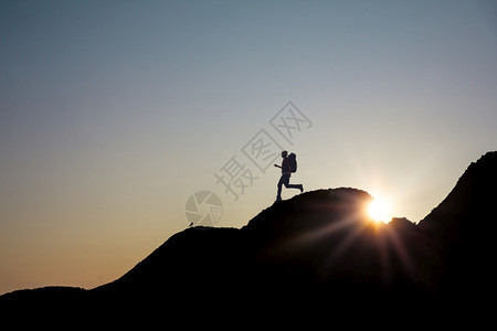挑战积极的悬崖一个男人在日落时翻过蒙塔尼的声图片