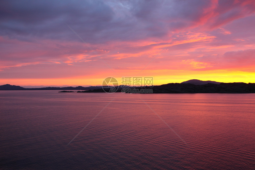 颜色春天从诺威海岸外的一艘船上看日落反射图片