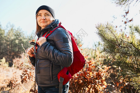 享受在阳光明媚的假期日上徒步快乐的妇女背着包走过森林的女在接近自然的地方渡暑假山旅行户外图片