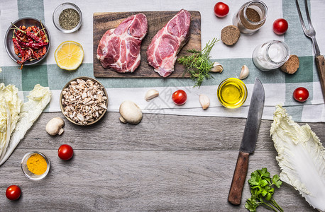 新鲜腰部健康食品烹饪概念的猪肉牛排配有蔬菜刀子水果香料和由文字框架位置以木制粗皮背景最高视野列出生的图片