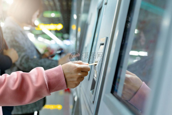 妇女从地铁买票后在火车上乘票交通概念商业离开地面图片