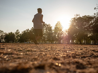 自然活动亚洲高年长男子在日落天空背景的公园里慢跑健康生活方式和保健概念高级的图片