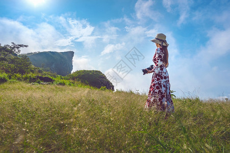 女孩风景站在草地上泰国清莱的PhuChiFa山拿着摄影机与照片志图片