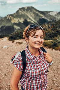 积极地游客喜悦微笑的快乐女人背着包在山上徒步旅行积极度过暑假走上山站在穆戈松旁的山路上峰背后的图片