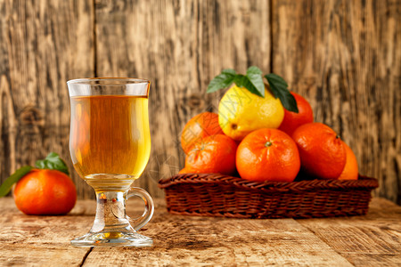 绿色杯子里的柑橘茶凉爽季节的温暖健康饮酒在模糊的旧木桌上堆在圆筒篮子的普通话和柠檬水果的背景将Citrus空间茶复制在一个玻璃杯图片
