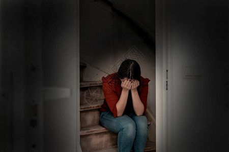 人们痛情感青年妇女哭泣坐在黑暗孤独悲伤和忧郁的女孩楼梯上头抱低紧