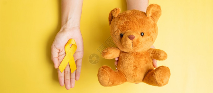 泰迪熊与黄色丝带预防癌症概念图片