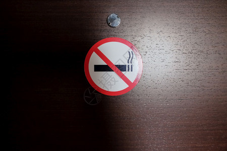 不良阻截香烟无标志卡在旅馆房间的木门上烟花牌公共场所的行为规则舒适健康横向视角被冲破了横风景图片