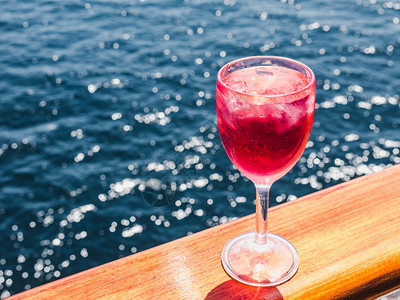 男在蓝海浪背景下的游轮露天甲板上美丽的粉红酒杯侧观特闭式休闲和旅行概念拿着美丽的粉红葡萄酒男士玻璃蓝色图片