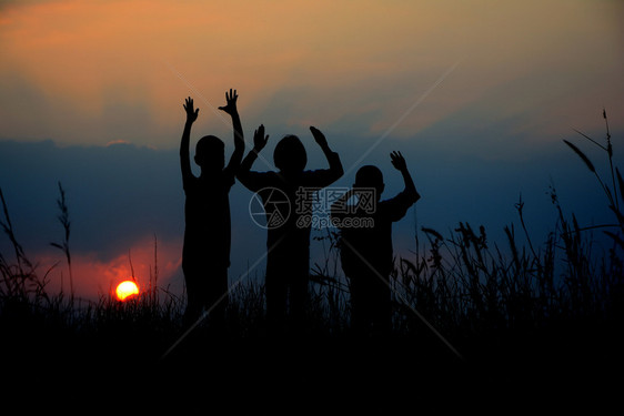 商业三个孩子的黑色轮盘一起站在日落时有天空学校女孩图片