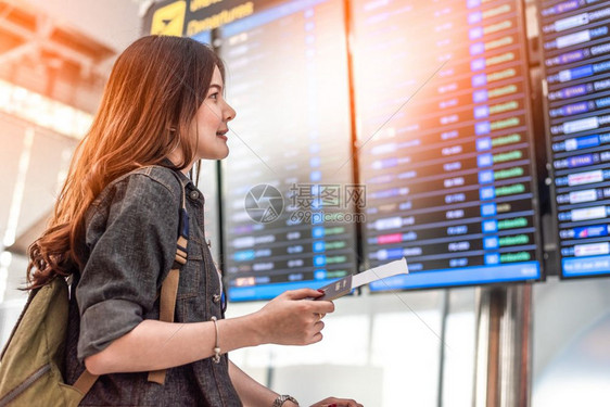 离开观察飞行时间的亚洲美容女旅游者在检查飞行时间表可以抽出间人与生活方式概念单身女主题的旅行与快乐生活BackView肖像手提箱图片