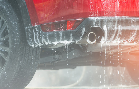 车站胎红色紧凑型SUV车带有运动和现代设计洗的红色小型SUV车用肥皂洗现代设计涤包括白泡沫汽车护理服务业概念在玻璃蜡和涂层汽车前图片