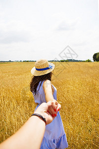 快乐的一个穿蓝裙子女孩站在她背上一个小麦田穿着蓝色衣服的女孩站在她背上一个小麦田里庄稼图片