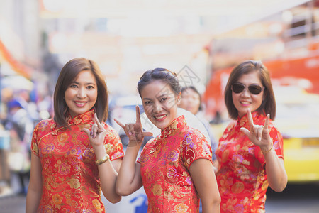 红色的一群穿着传统服装的亚洲女面带快乐的情绪和手语微笑着容我爱你露齿的镇图片