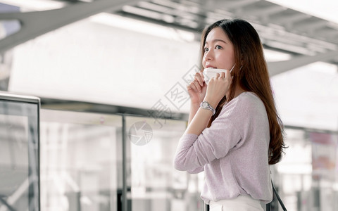 卫生人群上市关注亚洲女在使用公共交通和站在许多人中间的同时为保护而用警惕面具来保护的新常识概念以及图片