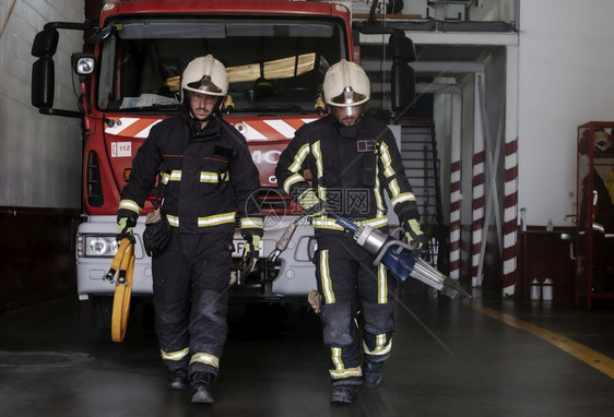 保护的消防员离开站时装备齐全并配有灭火的工具水紧急情况图片