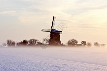 乡村的欧洲季节冬日落时荷兰农村传统风力车厂在冬季日落背景图片