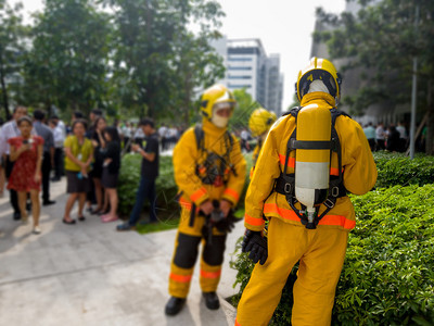 黄西装消防员的后座焦点和面氧气箱的座消防员是教职工他们要逃离高楼大消防车工人男演习图片