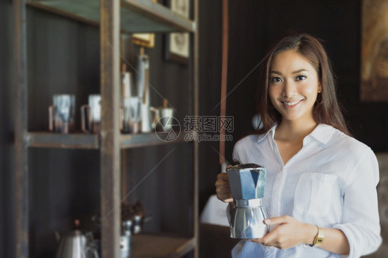 随意的商业亚洲女孩在成功的办公室工作后站在咖啡壶里笑一的亚洲女孩站着在咖啡店享受放松的乐趣移动图片