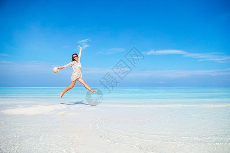 夏天喜悦海洋快乐的女子在浅水海滩上玩得开心在海滩上穿绿礼服的年轻时尚女子图片