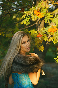 欧洲的微笑草公园里美丽的金发年轻女绿树的图片