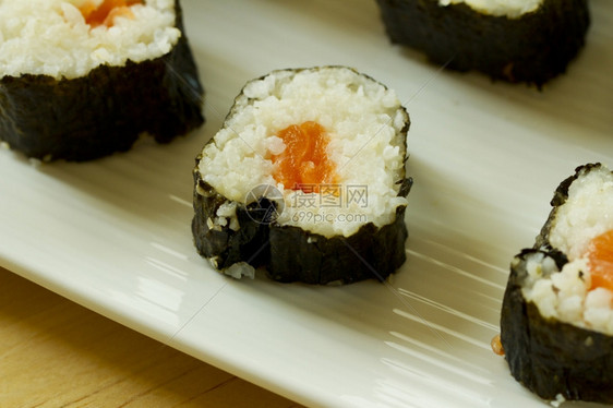 亚洲人盘子近距离的寿司和白盘上鲑鱼生姜图片