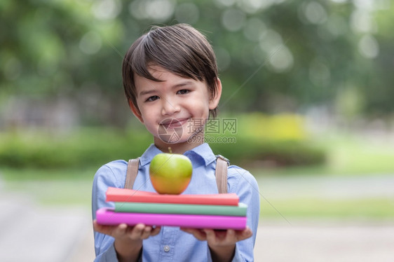 户外拿着苹果准备上学的小男孩图片