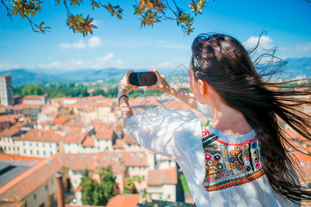 年轻caucasian女在观察所用手机拍摄欧洲老城的照片在观察所用手机拍摄照片时使用手机拍到的YoungCaucasianwom图片