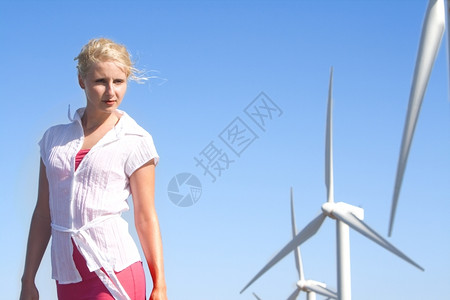 美丽年轻女子梦想着未来在叶左发电机下的风力农场上女孩雏菊图片