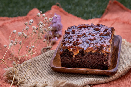 棕色的传统自制甜面包花椰子奶豆蛋糕在美丽的背景上配有焦糖和黄油烘烤的图片
