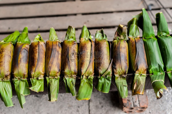 小吃包裹由大米面团和香蕉叶包着的甜椰子制成传统亚洲甜点的图片