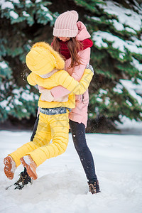 幸福的家庭在冬季寒雪日玩球快乐母亲和孩子享受冬雪日的快乐白色年轻女儿图片