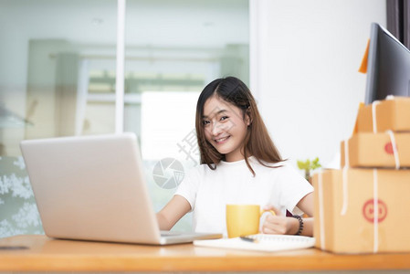 盒子互联网女孩亚洲妇在交付服务和网上购物业主题中拥有包裹箱的分娩服务和在线购物业包箱和亚洲妇女非全时和生活方式概念图片