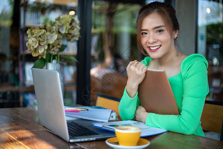 愉快闲暇亚洲女读书微笑快乐在成功的办公室工作后在咖啡店放松保持图片