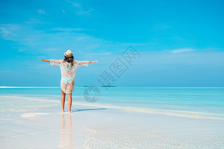 自然海滩度假的年轻美女海滩上穿绿裙子的时装女青年在海滩上休息田园诗般的图片