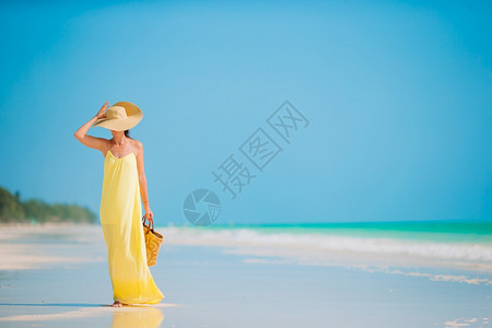 在海滩上穿绿衣服的年轻时装女尚穿着绿色服装水奢华闲暇图片