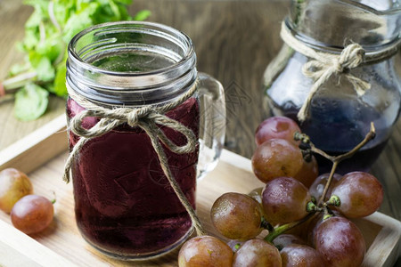 品尝美丽的木桌上鲜葡萄和果汁季节图片