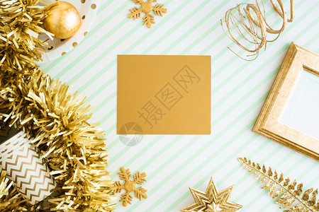 假期火花圣诞快乐和新年金贺卡观赏在绿条线桌礼堂庆祝贺卡式模型展示设计时闪亮的金银罐球彩珠装饰品展出海报图片