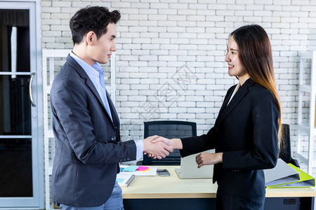 公司男人白种亚洲女商和在签署合同或握手问候交易后在办公室背景中与亚洲女商人和握手企业表示信心大有雄而且成双对以及图片