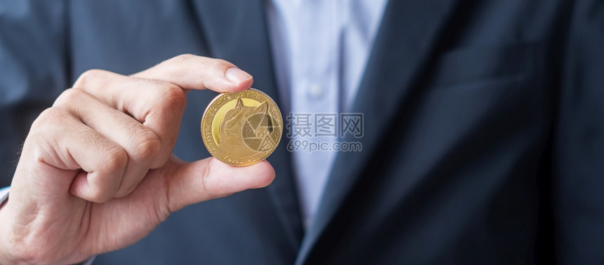 链投资互联网持有黄金的商人手持Dogecoin加密货币是连锁网络内的数字金钱利用技术和在线交流分散金融概念进行交换c使用技术与网图片