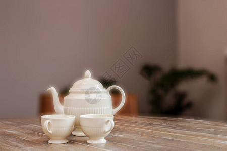 木制桌上的茶壶和杯子家用旧式设计中的生活仍维持在古老设计中可爱而舒适有文字空间现代室内茶壶和木制餐桌上的杯子家用旧型设计中的生活图片